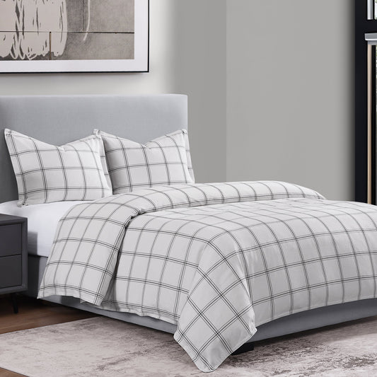 Gray and white checkered bedding set on a bed in a bedroom.