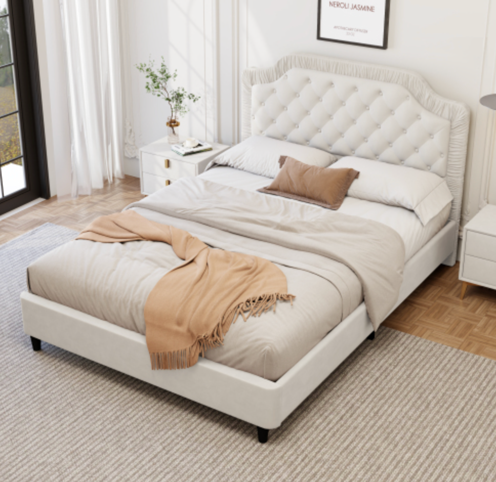 White upholstered bed with beige blanket and pillow in a bedroom setting
