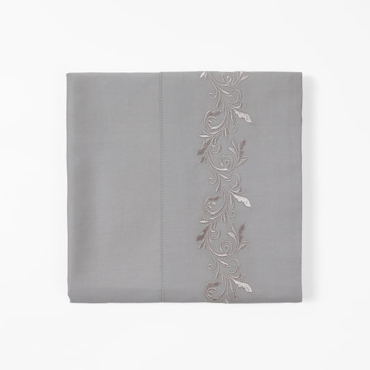 Gray pillowcase with floral embroidery on a white background