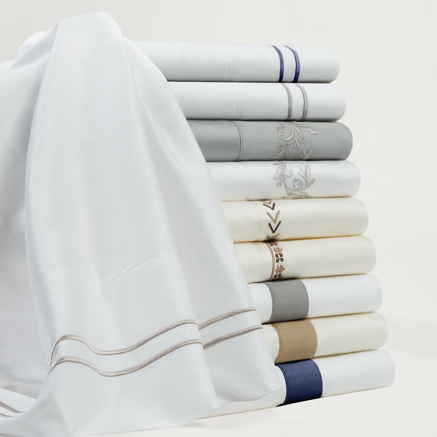 Stack of neatly folded towels in various colors on a light background