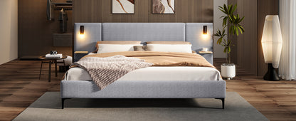 Gray upholstered bed in a modern bedroom with wooden flooring and decor.
