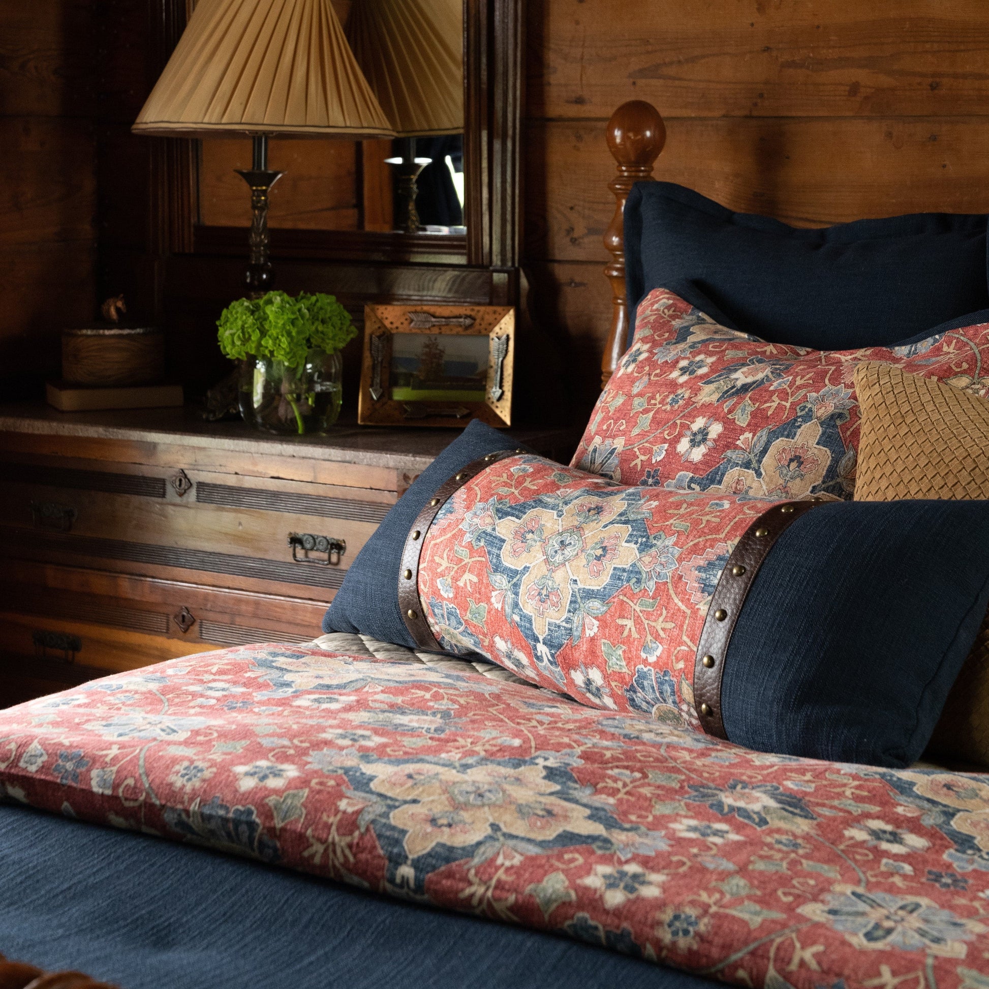 Floral-patterned sofa with decorative pillows in a rustic room setting.