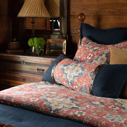 Floral-patterned sofa with decorative pillows in a rustic room setting.
