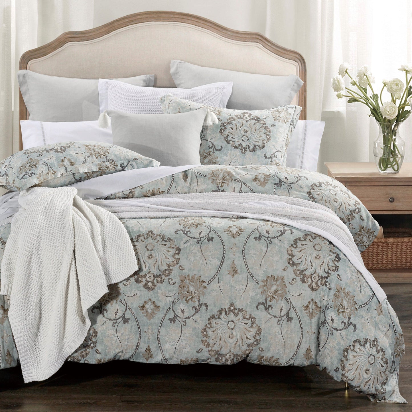 Bed with floral patterned bedding and white pillows in a bedroom setting.