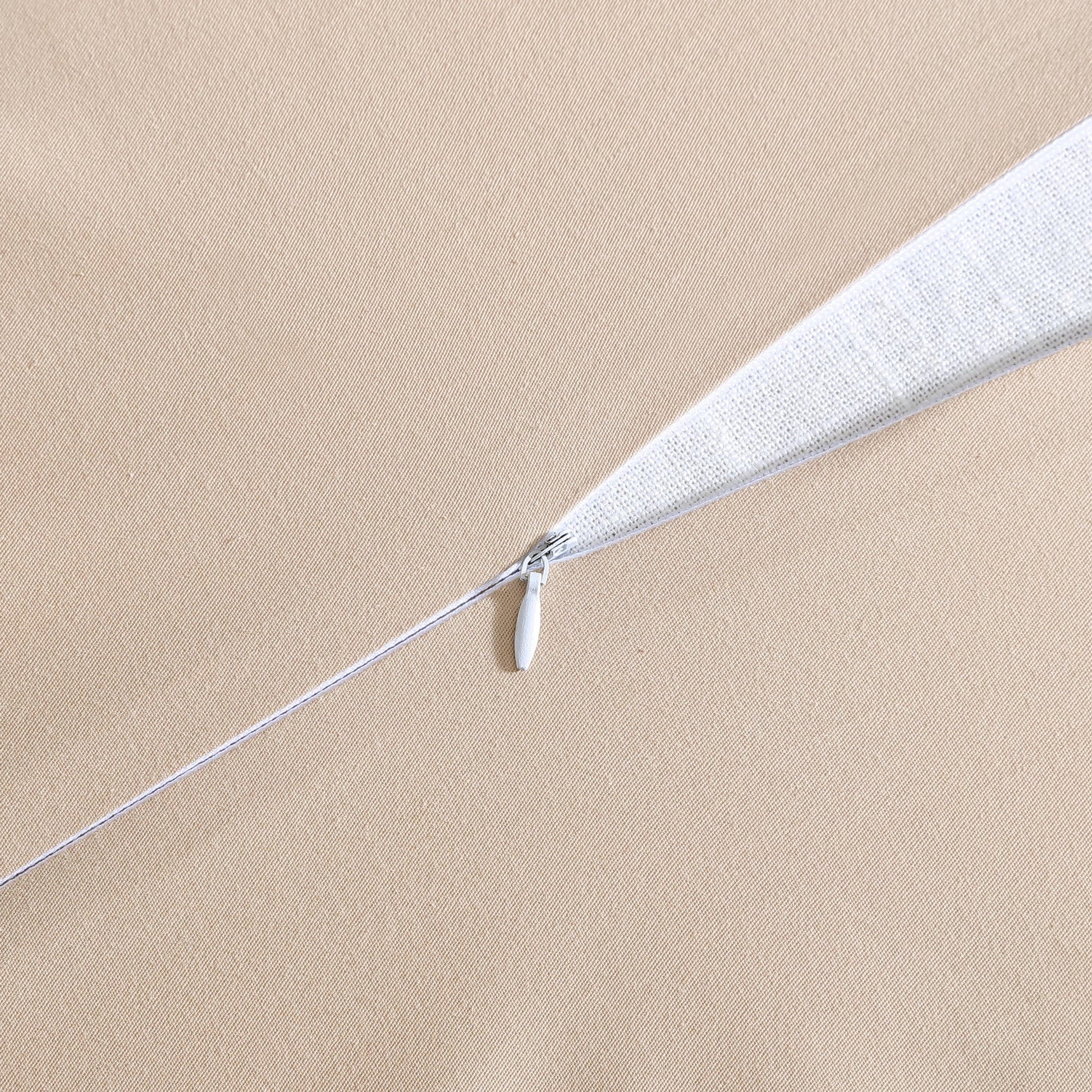 Close-up of a white feather duster on a beige background