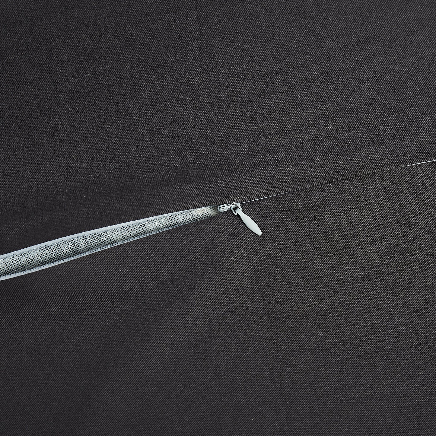 Close-up of a fishing line with a hook on a dark fabric background