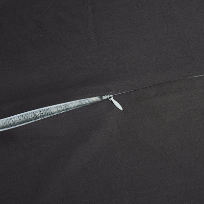 Close-up of a fishing line with a hook on a dark fabric background