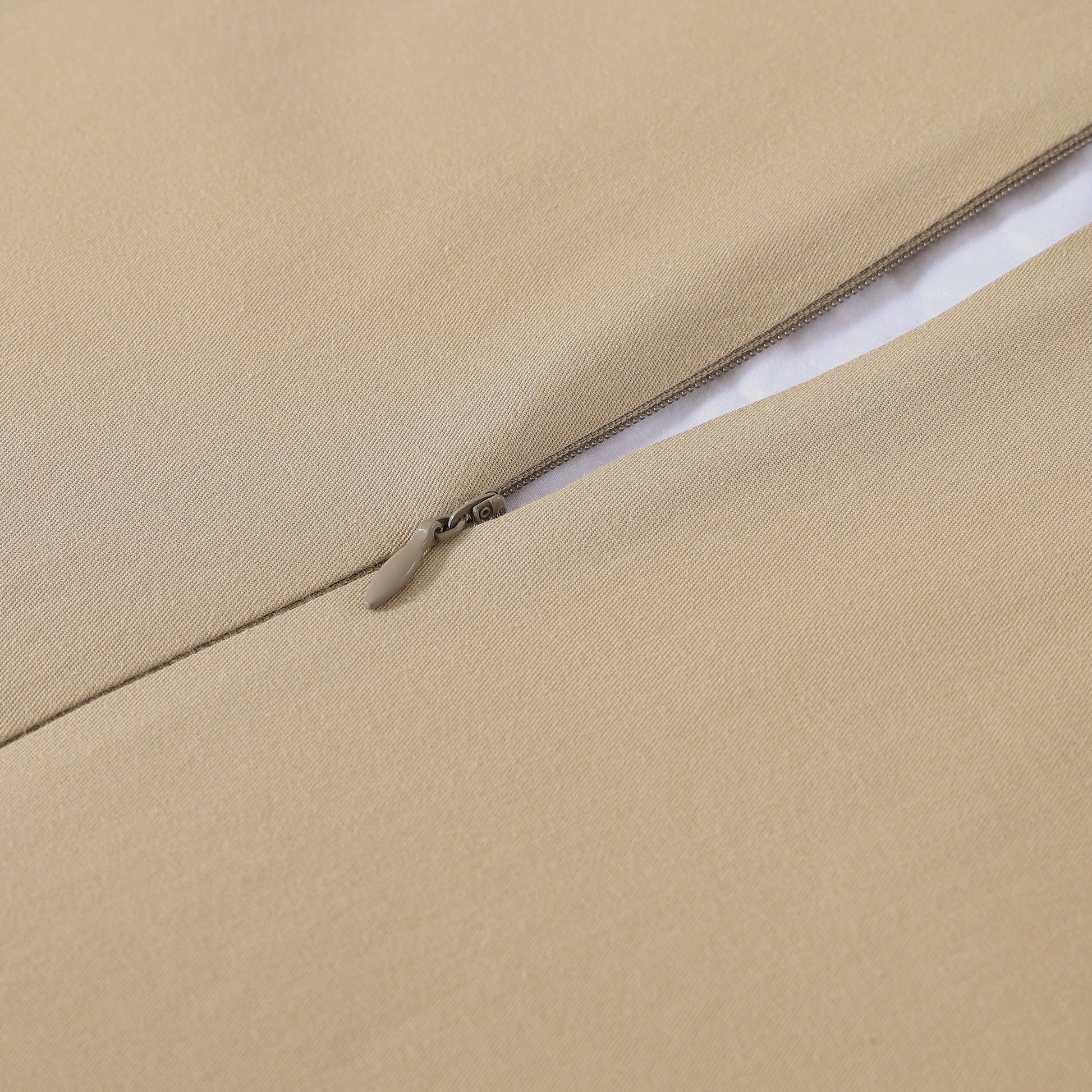 Close-up of a beige fabric with a zipper running along the edge.