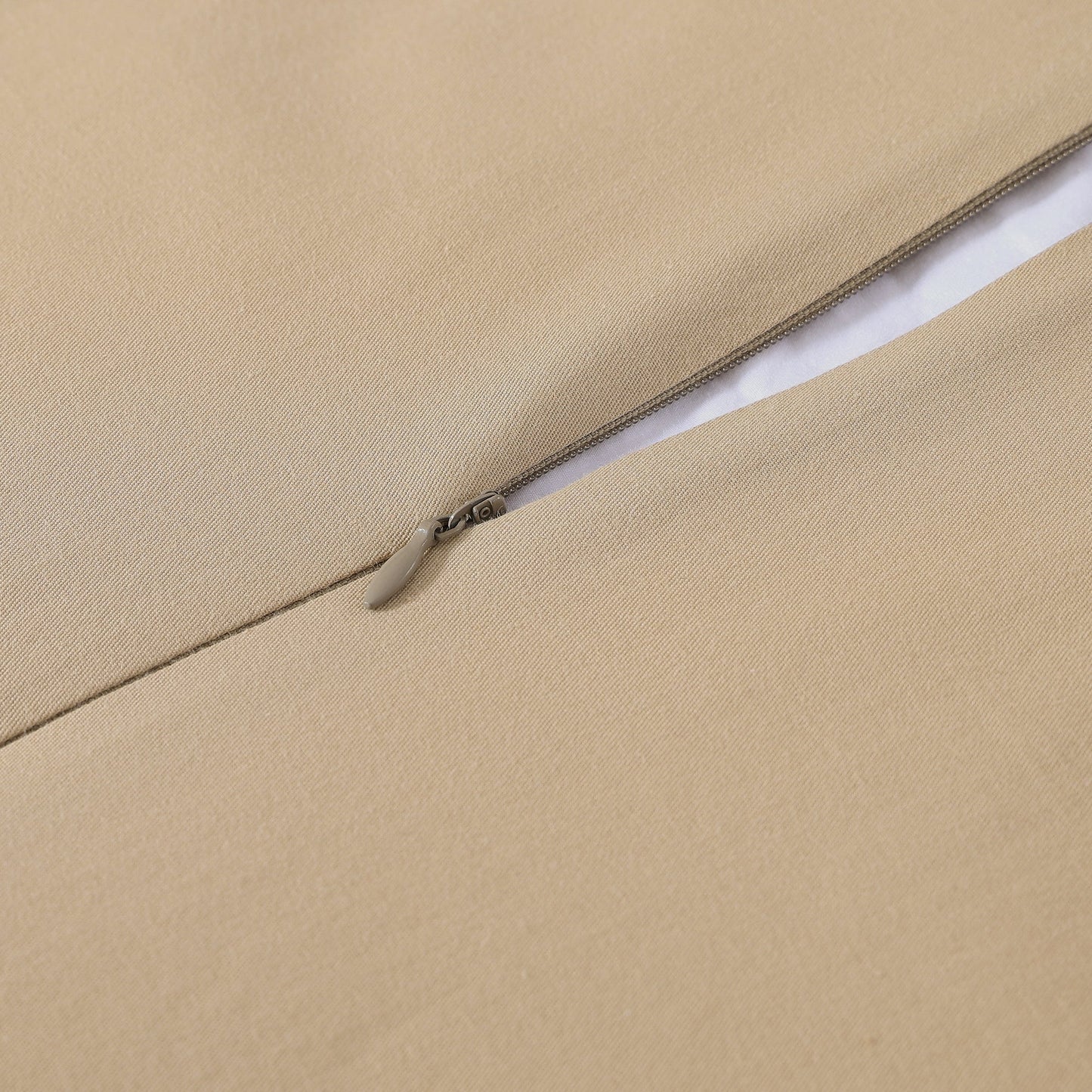 Close-up of a beige fabric with a zipper running along the edge.