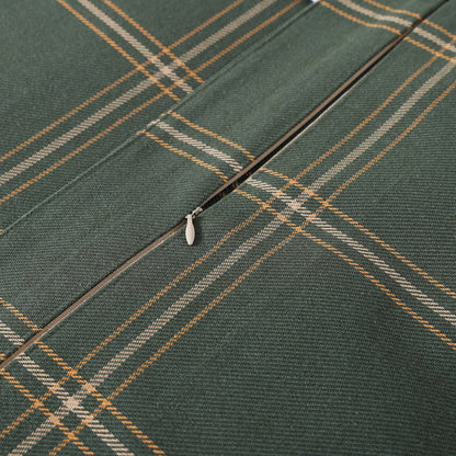 Close-up of a green fabric with plaid pattern and zipper