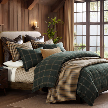 Bedroom with plaid bedding and pillows in a cozy room setting.