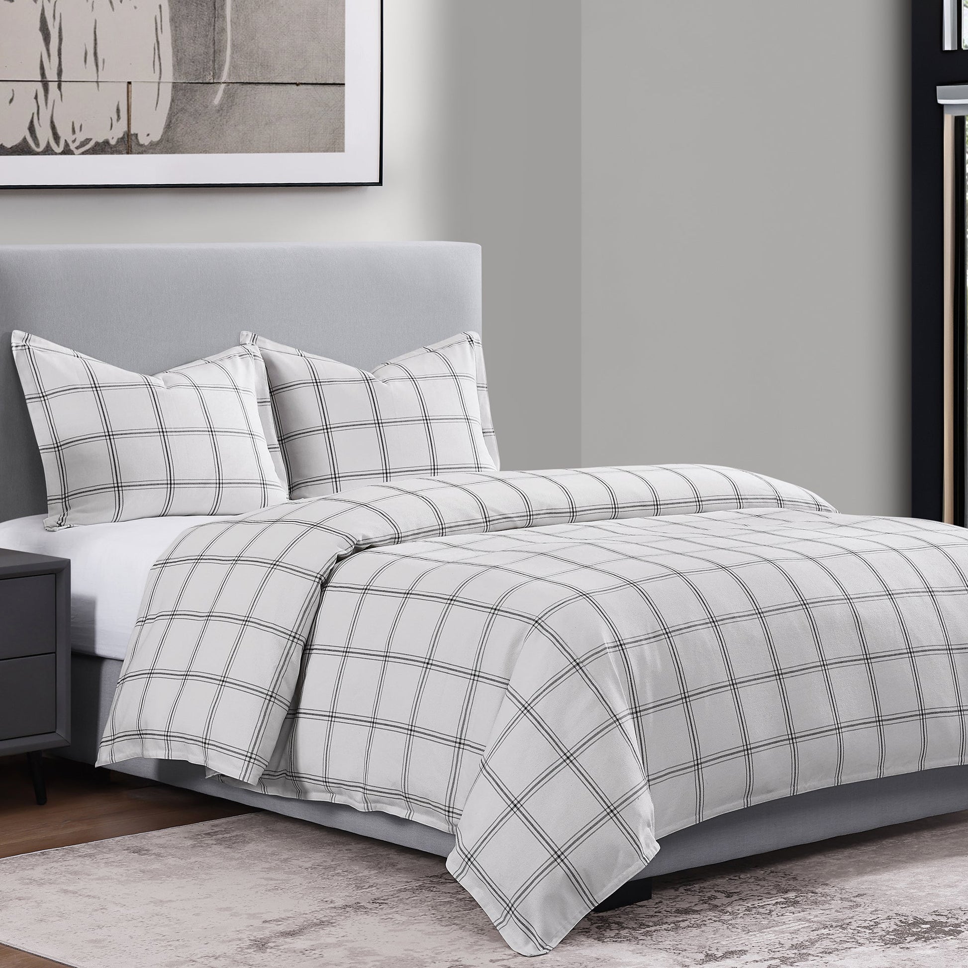Gray and white checkered bedding set on a bed in a bedroom.
