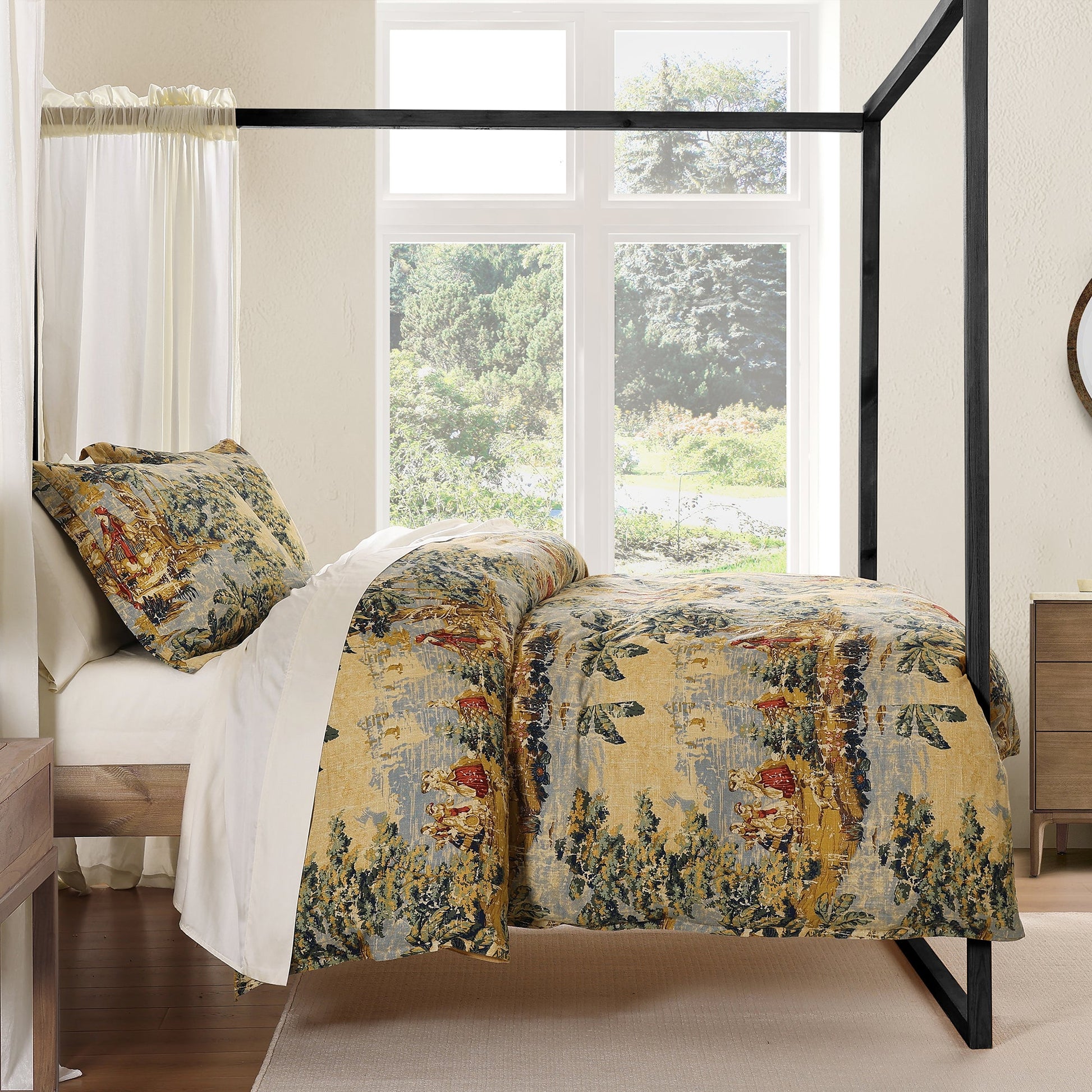 Bed with floral bedding in a bright bedroom with large windows.
