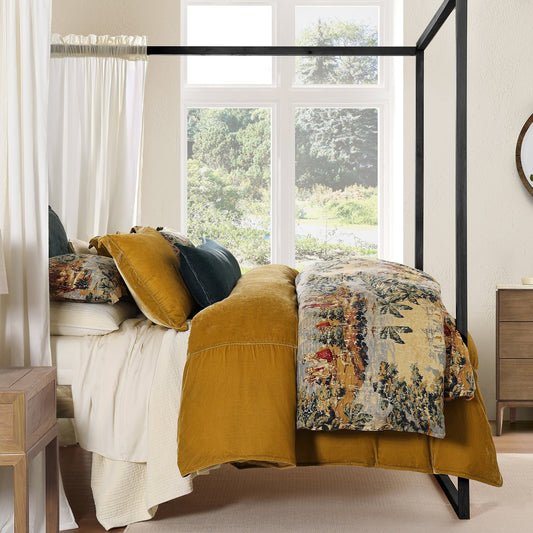 Bedroom with a four-poster bed featuring a floral comforter and mustard yellow throw blanket.