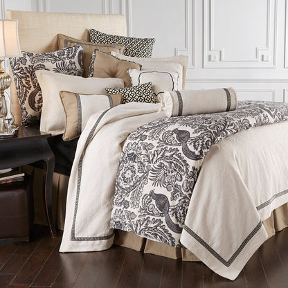 Neatly made bed with patterned bedding and pillows in a bedroom setting.