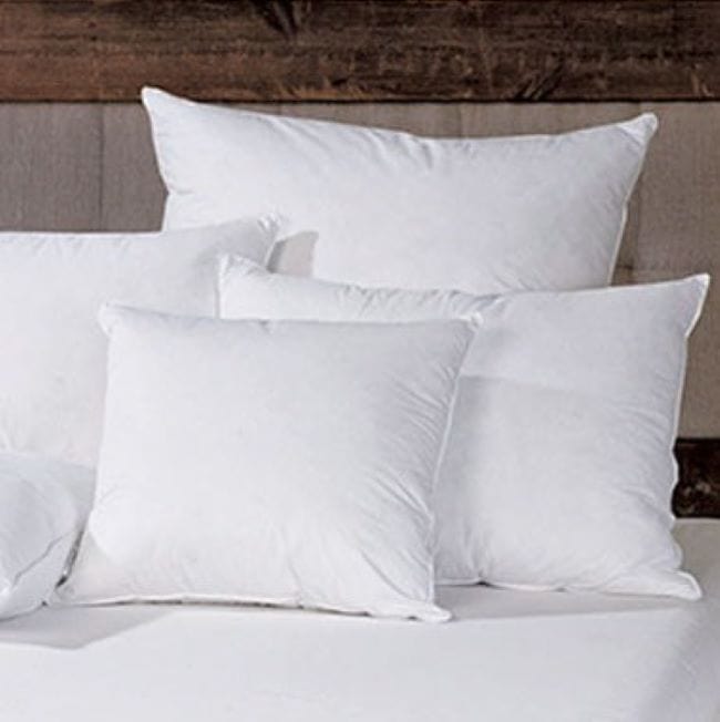 White pillows on a bed with a wooden headboard