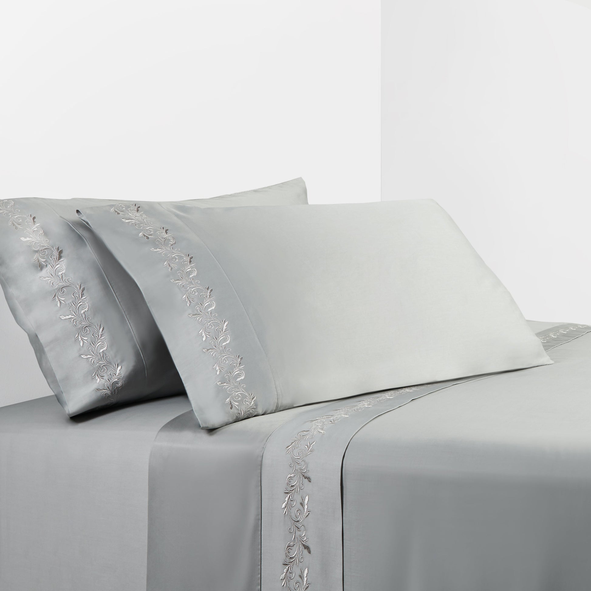 Gray bed sheet set with floral embroidery on a white background