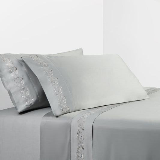 Gray bed sheet set with floral embroidery on a white background
