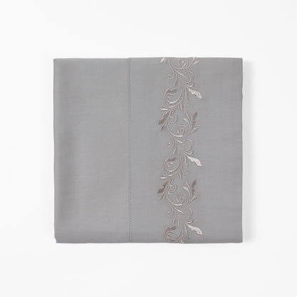 Gray pillowcase with floral embroidery on a white background