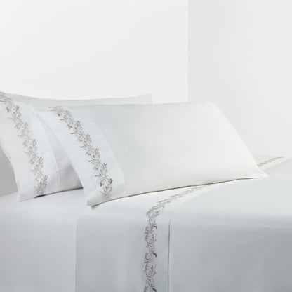 White bed sheets with silver embroidery on a white background