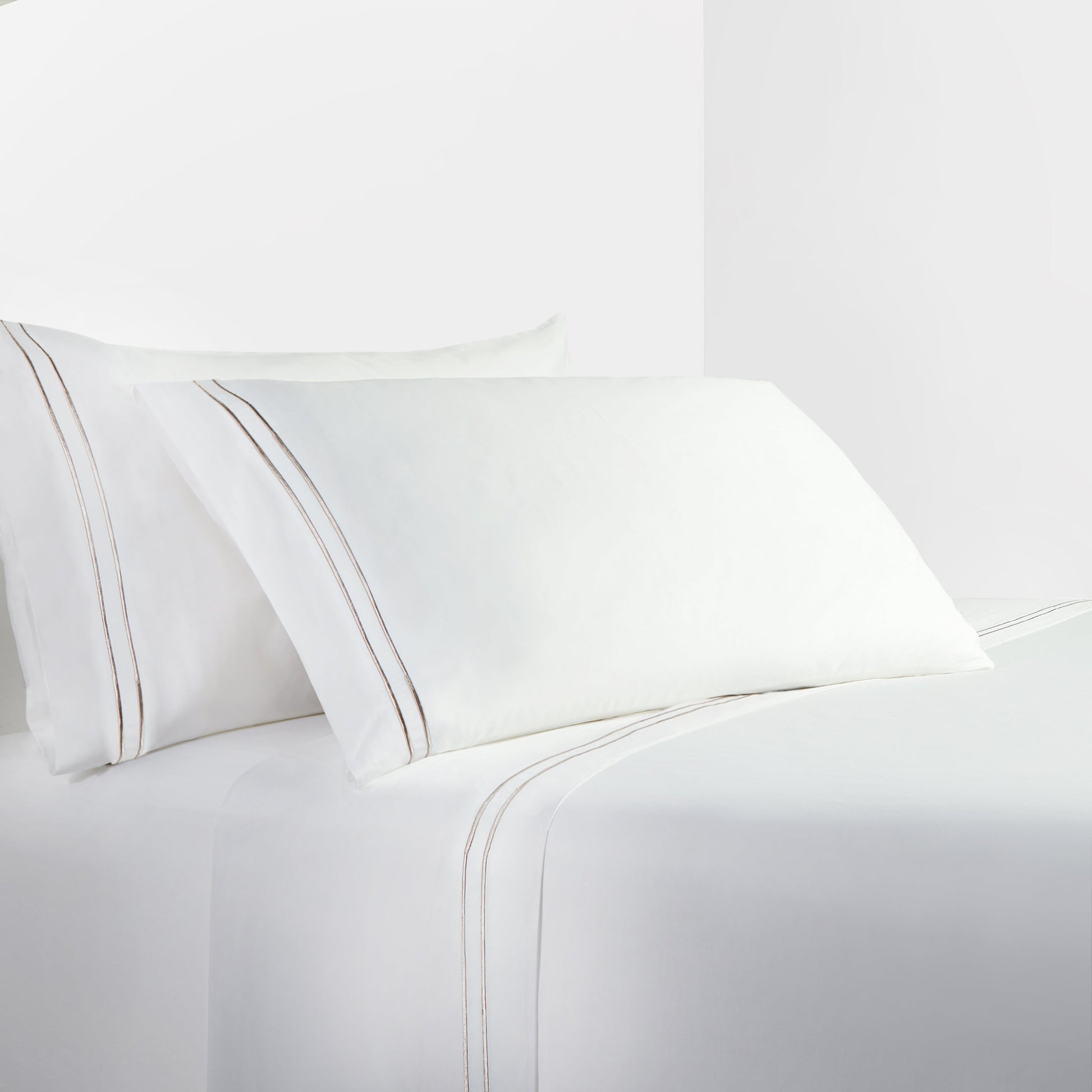 White bed sheets and pillowcases on a white background