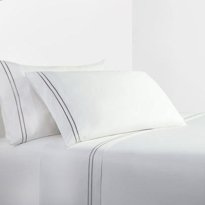 White bed sheets and pillows with a subtle stripe on a white background