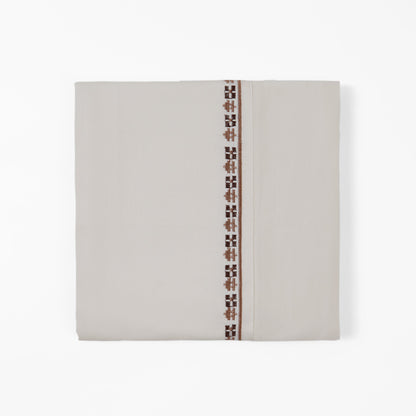 Beige fabric with a decorative brown pattern on a white background