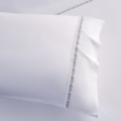White pillowcase with decorative trim on a light gray background