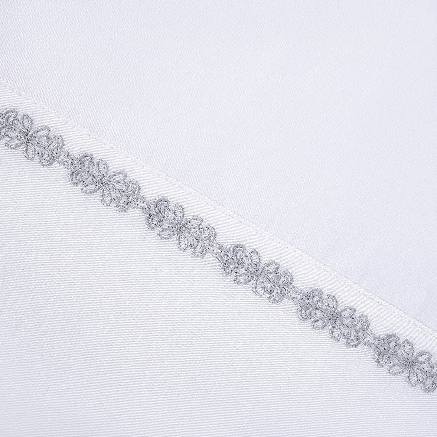 Decorative silver lace trim on a white background