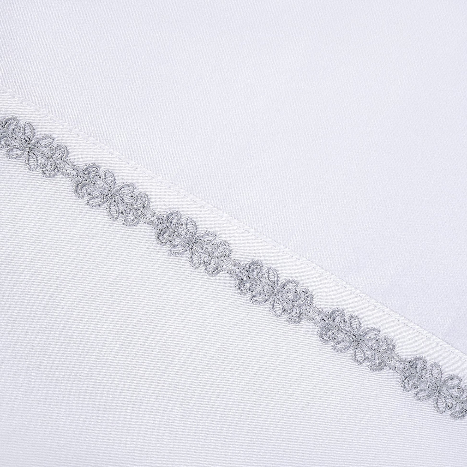 Decorative silver lace trim on a white background