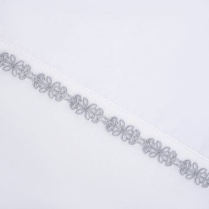 Decorative silver lace trim on a white background