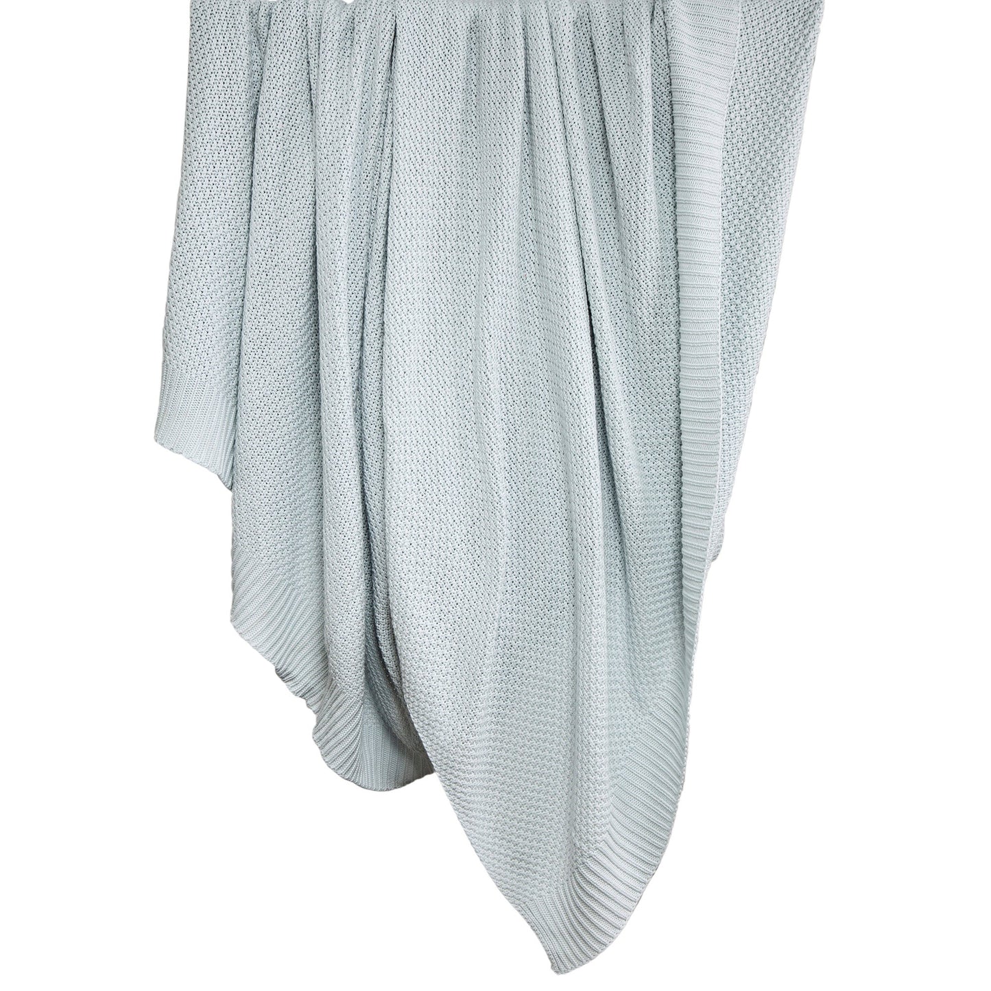 Light blue knitted blanket draped over a white surface