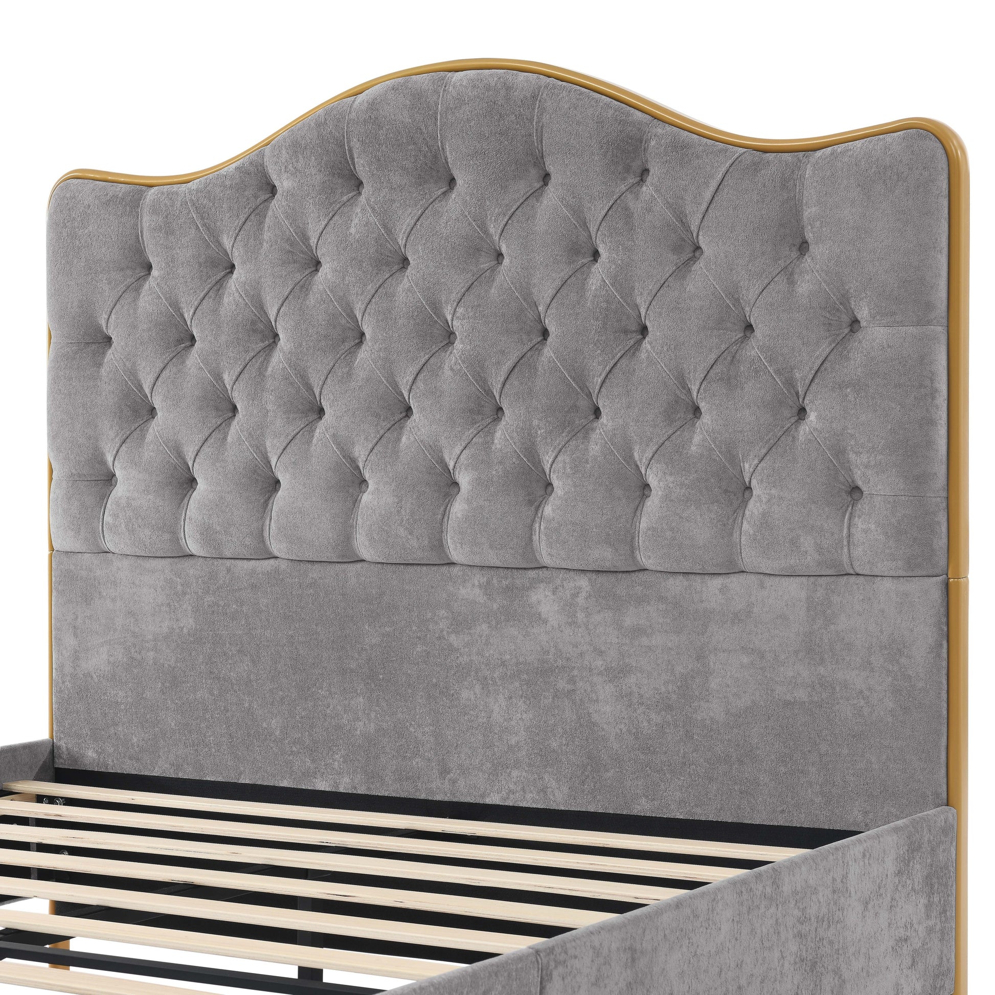 Gray tufted headboard with gold trim on a bed frame.