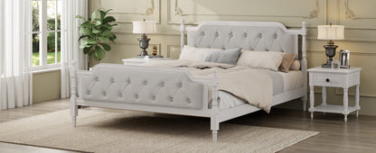 Neatly made bed in a bedroom with white bedding and gray headboard.